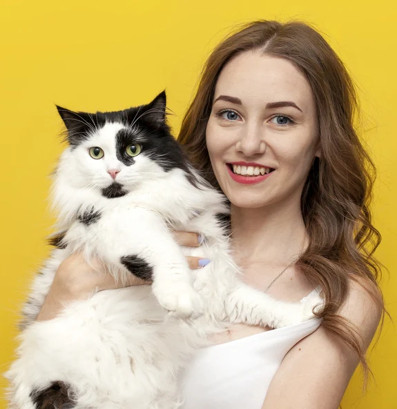 Happy pet owner smiling and holding up cat