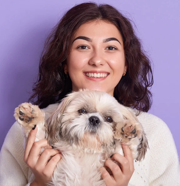 Smiling pet owner holding puppy